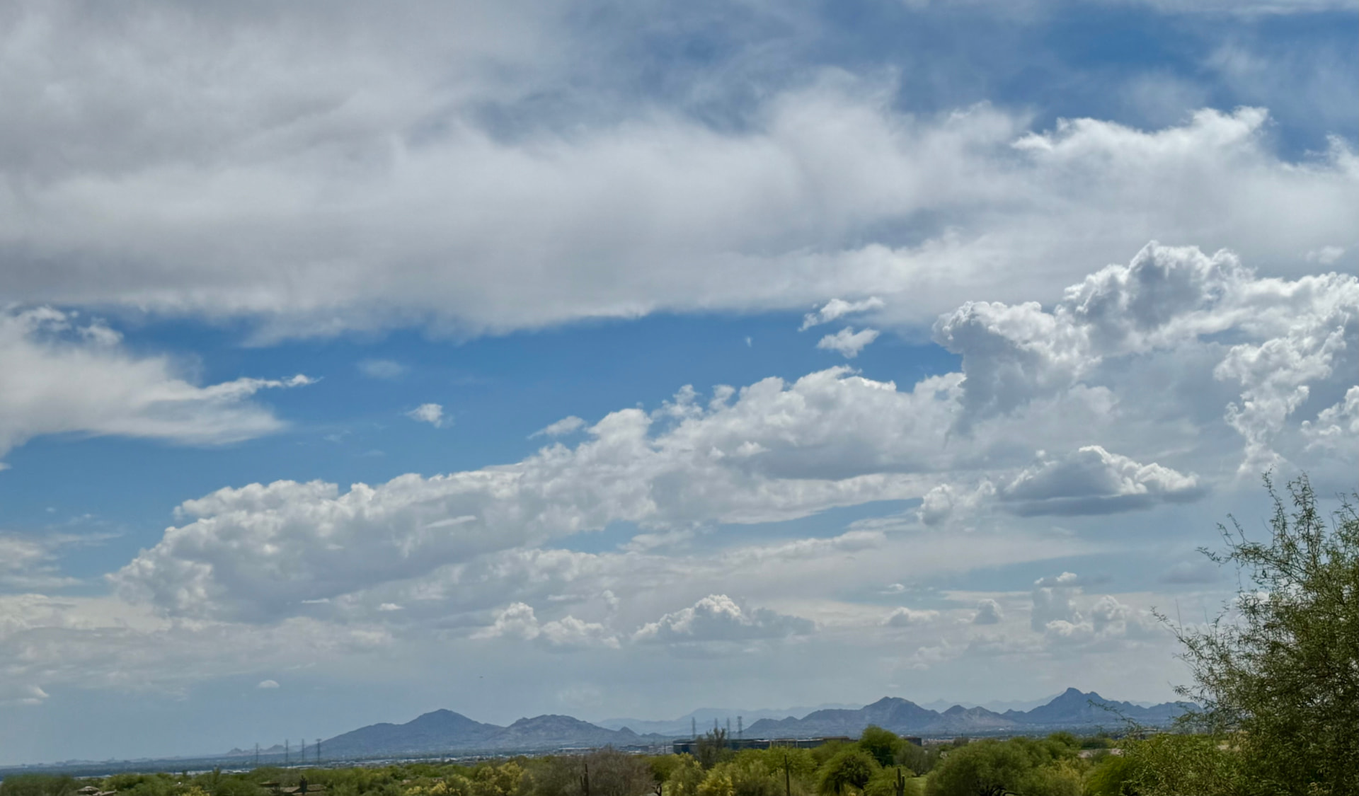 Blue sky and clouds over the Arizona mountain range on the desert horizon